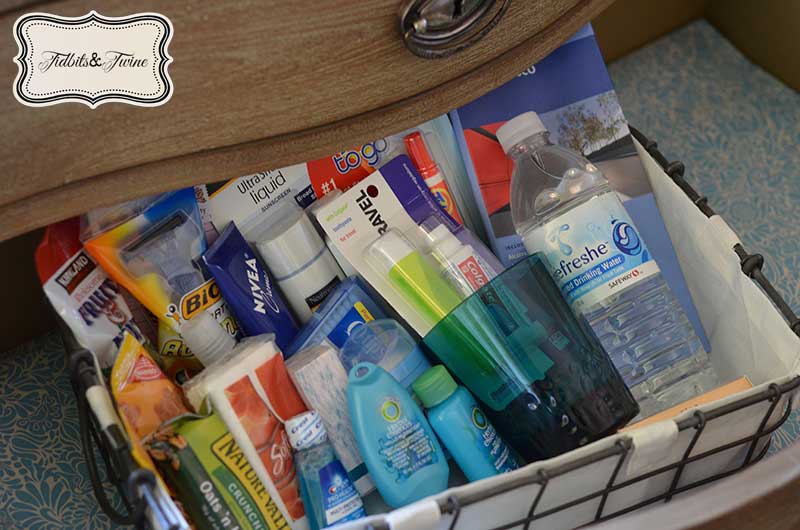 guest basket make of wire in drawer full of guest room and guest bathroom essentials like water snacks and toiletries