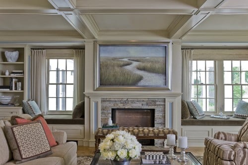 tv above fireplace that is covered by artwork