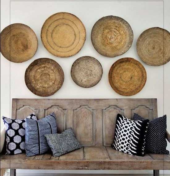 Collection of round baskets hanging above a wooden bench