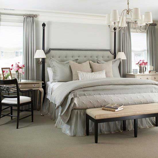 Black four poster bed with gray tufted headboard gray walls and gray curtains