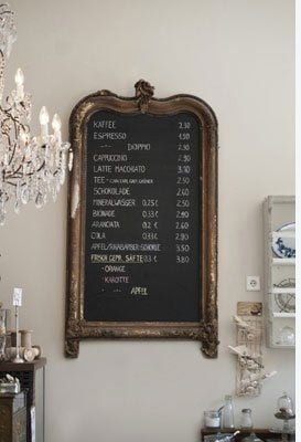 Black chalkboard inside an antique gold frame in a kitchen