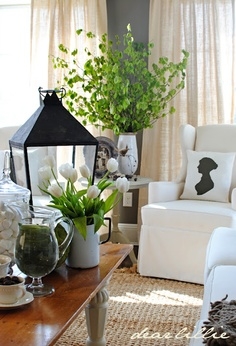 Living room with white wingback chairs with white pillows with black silhouettes on them