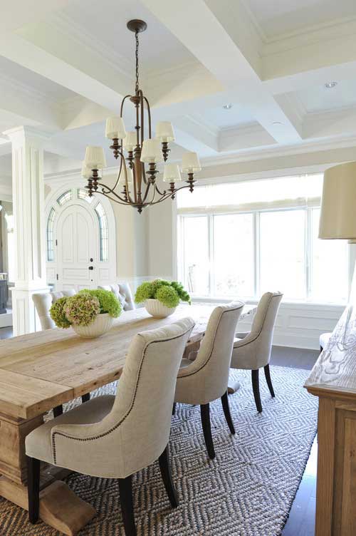 Dining room with rustic table and contemporary beige dining chairs and hydrangea centerpiece