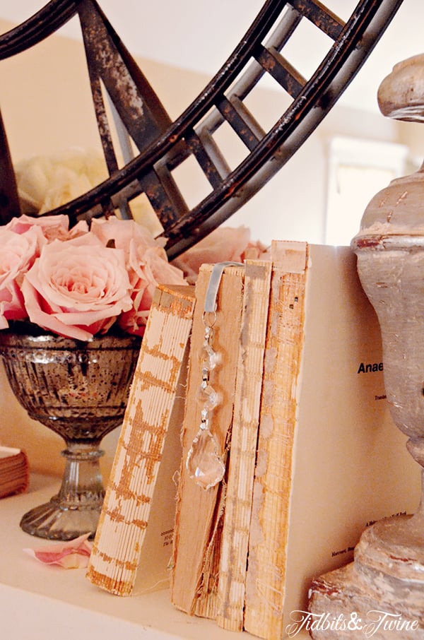 Fireplace mantel decorated with vintage books and crystal