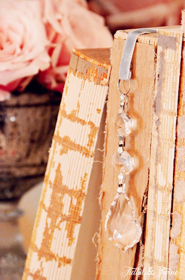 Antique books with a crystal bookmark and pink roses in silver vase