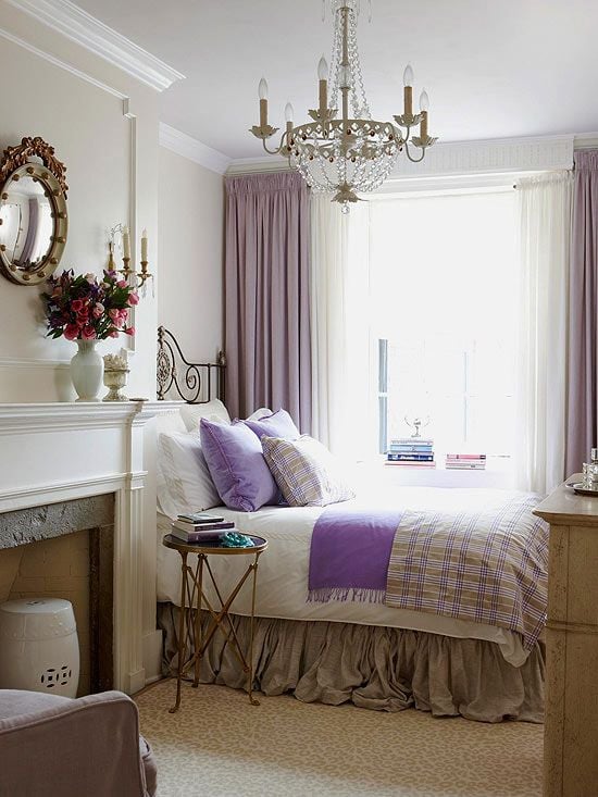 French style bedroom with white fireplace purple curtains and purple accents on the bed