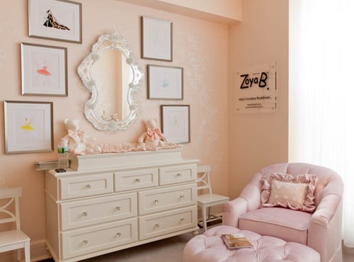 Girls room with pink walls and pink swivel chair and gallery wall over dresser