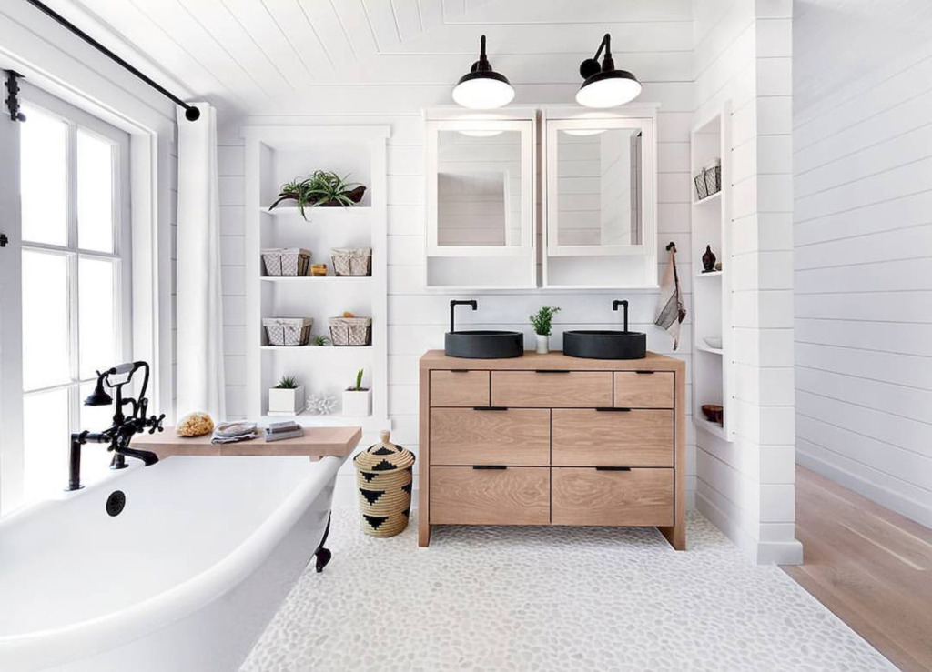 Bathroom with shiplap walls pebble floor and freestanding tub