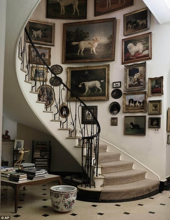 Stairway wall filled with large gallery wall of dog paintings