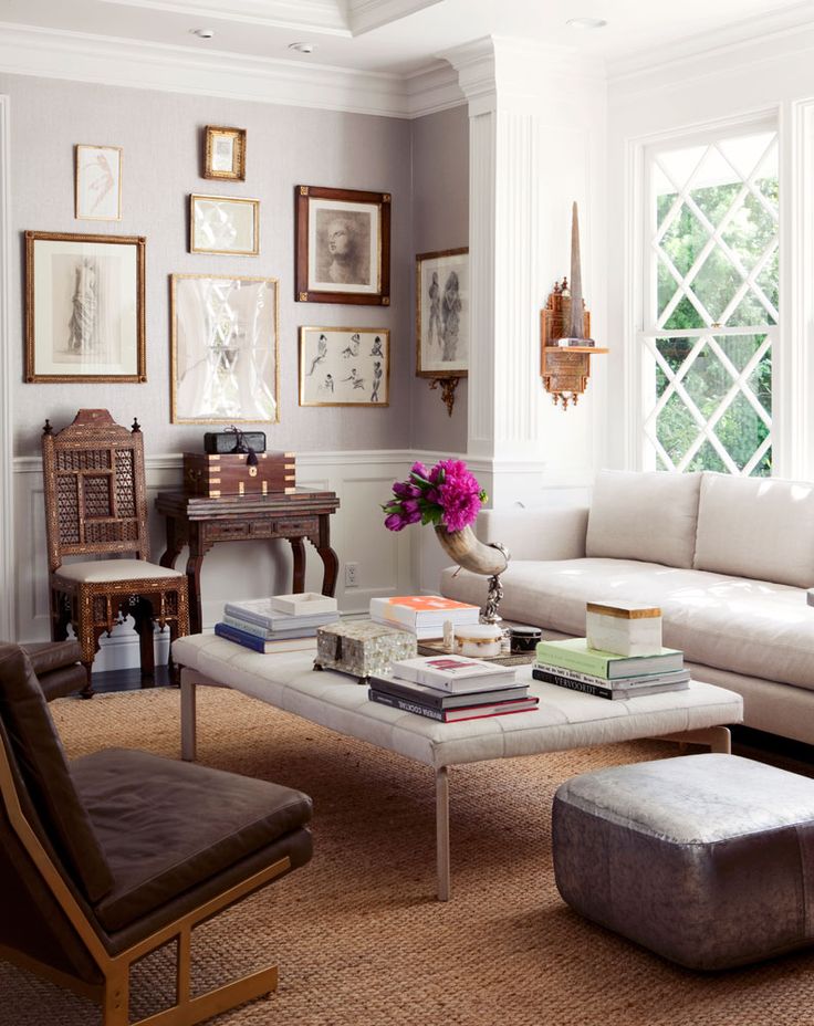 Eclectic living room with gallery wall and tufted ottoman holding books