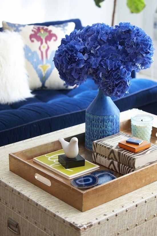 Trunk coffee table with brown tray on top and blue hydrangeas in a blue vase