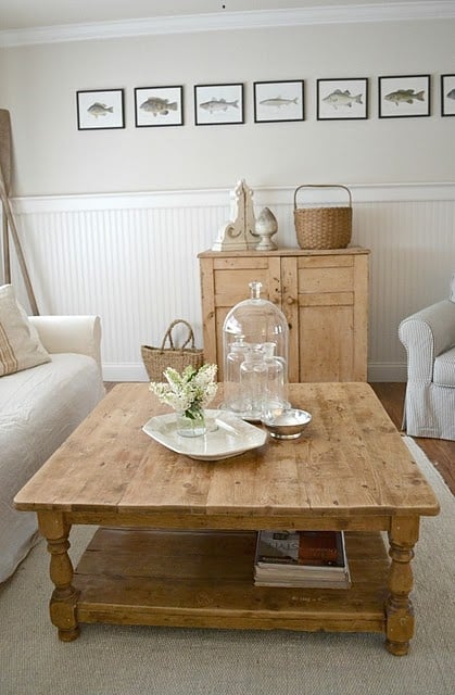 Rustic wooden coffee table with glass cloche and white flowers