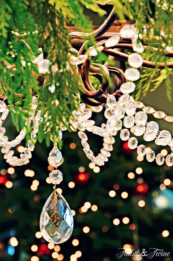 french chandelier with crystals decorated for christmas with greenery