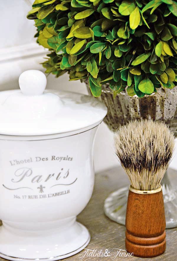 French bathroom container holding q-tips and mercury glass compote with preserved boxwood bathroom decor