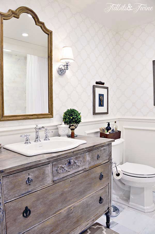 bathroom with dresser as a vanity wainscotting and wallpaper