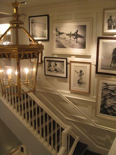 white staircase with millwork that includes large framed beach photos from floor to ceiling