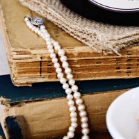 closeup of vintage books with white pearl necklace draped across them