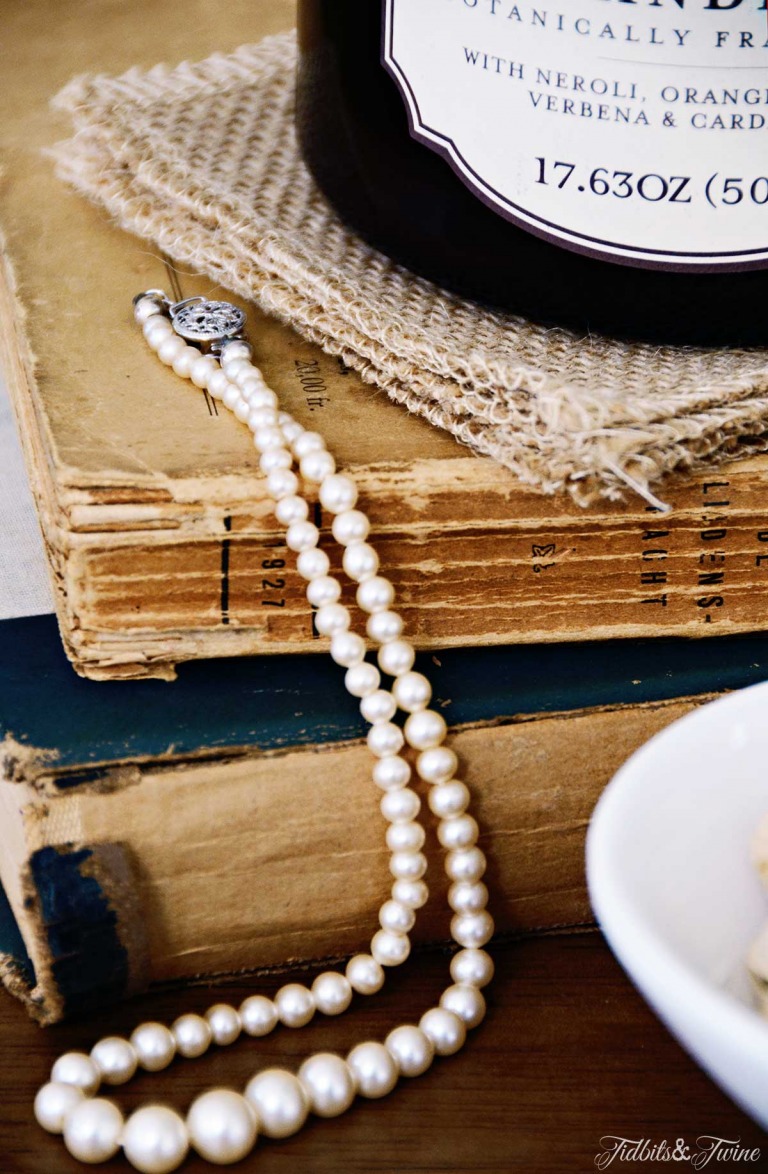 closeup of vintage books with white pearl necklace draped across them