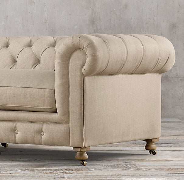 {A button-tufted sofa with the fabric tucked - not stitched - into the tufting to create a diamond pattern}