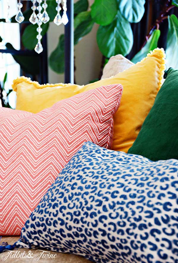 grouping of coloring throw pillows on sofa with a mix of patterns