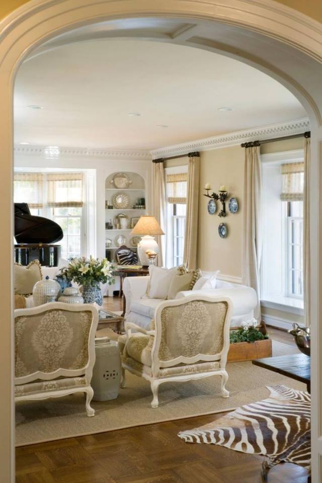 formal living room with arched entryway and layered rugs