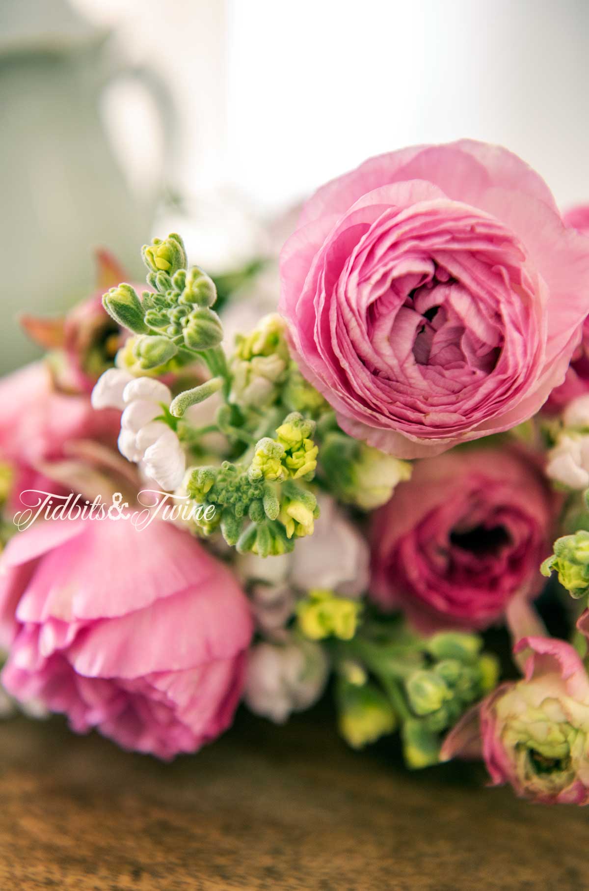 pink peonies mixed with white snap dragons lying on wood table
