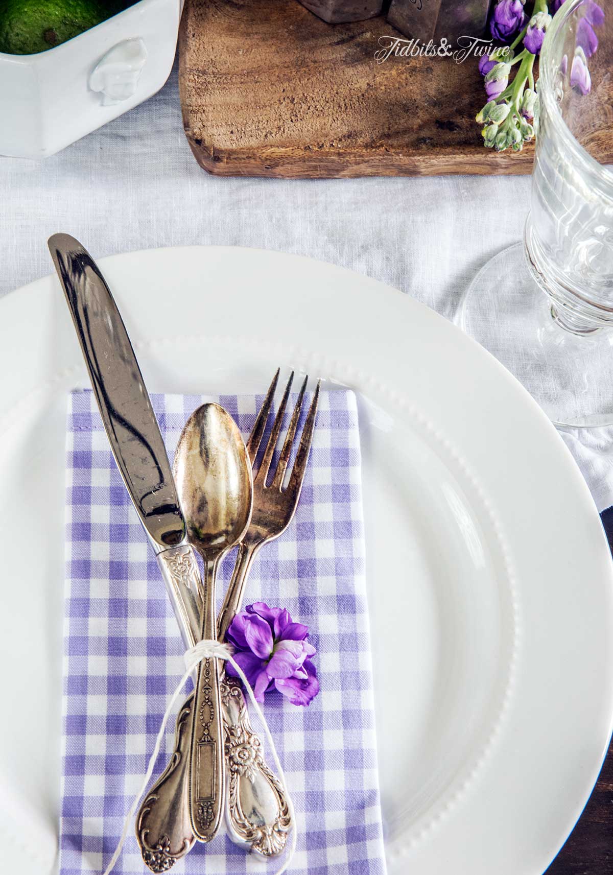 Spring place setting with purple and white checkered napkins and vintage flatware