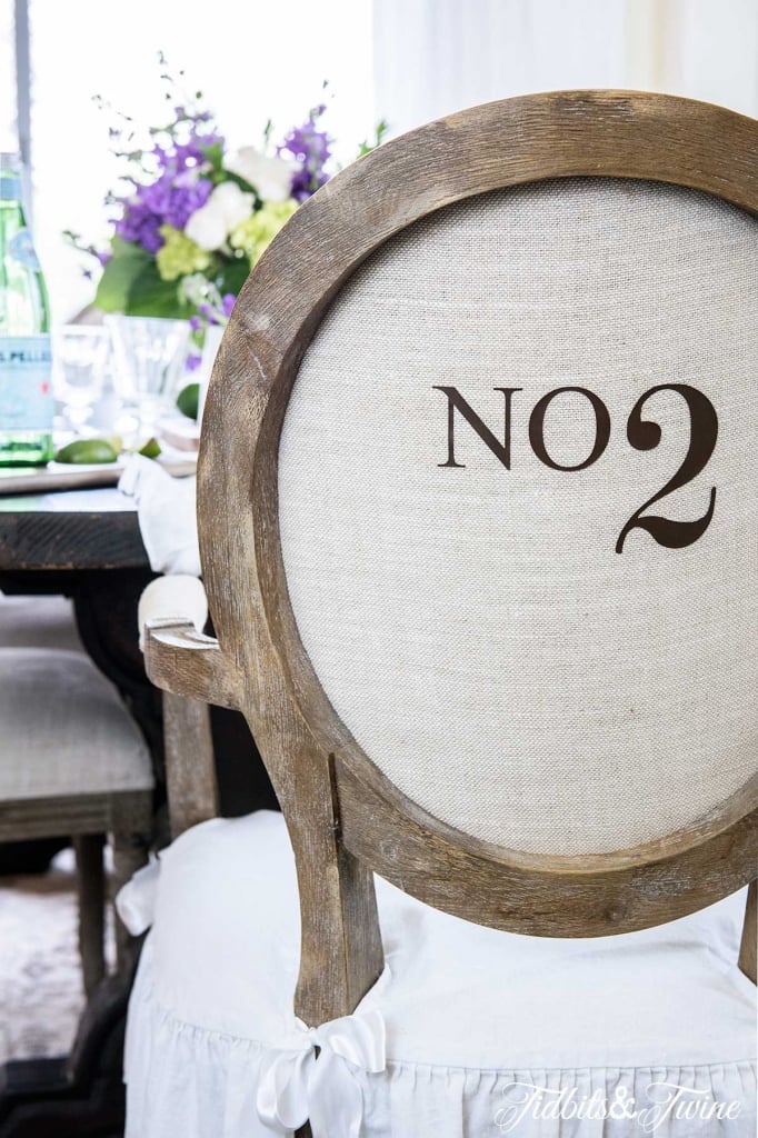 Numbered French dining chair closeup in dining room with purple and white flowers