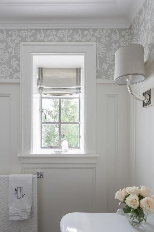 small bathroom with white trim on bottom and gray floral wallpaper on top