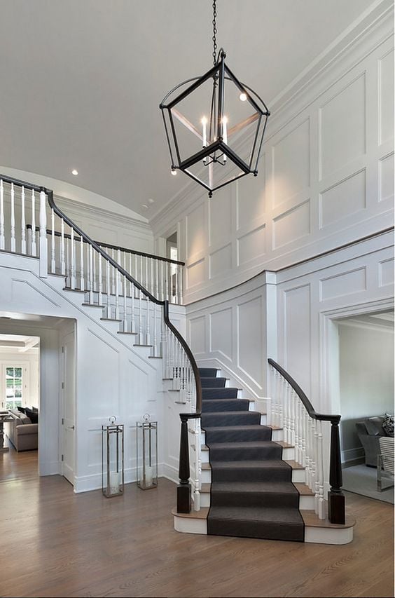 White board and batten wall trim going up a flight of stairs in an entryway