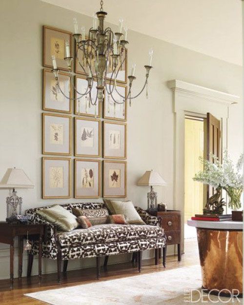 Grouping of 12 frames above a sofa in a traditional living room