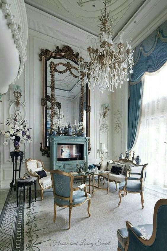 White an blue french elegant living room with gold mirrors crystal chandelier and blue curtains