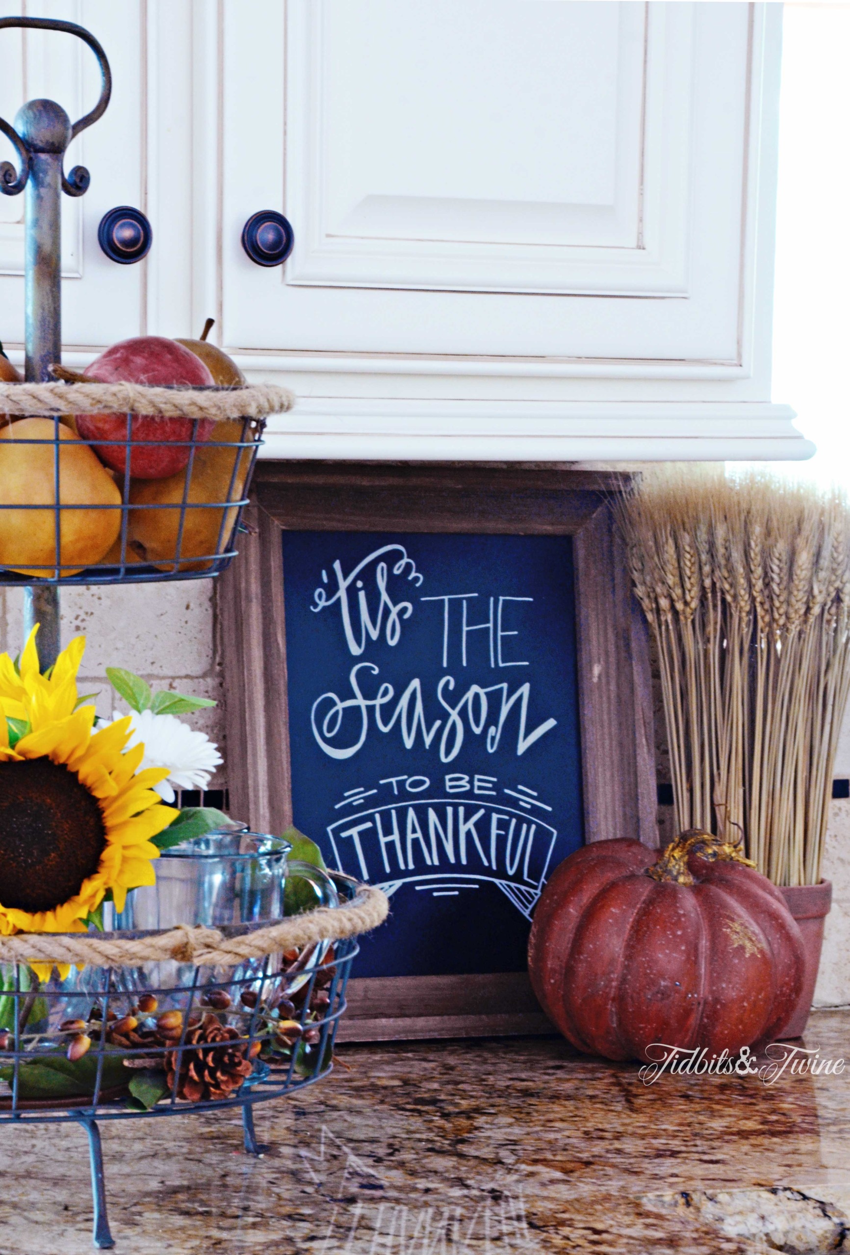 Wire basket holding fruit and sunflowers on kitchen counter for Fall