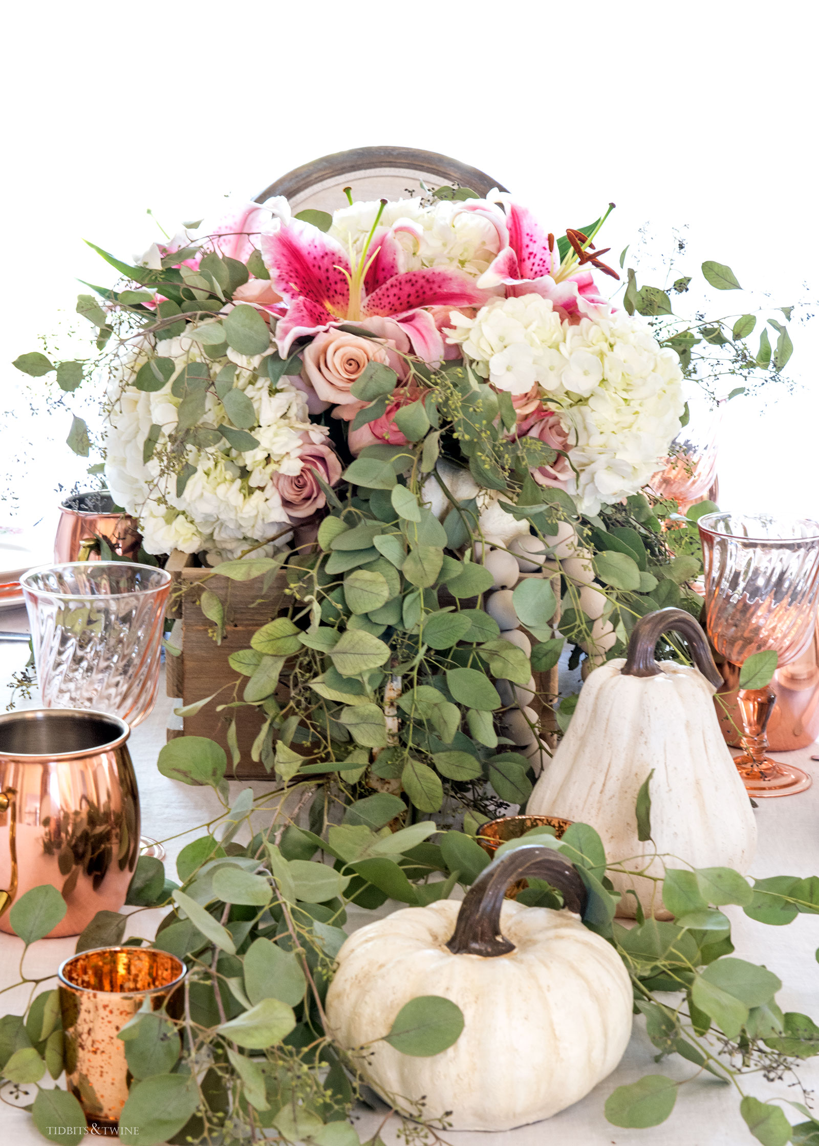Fall dining table with wooden box overflowing with eucalyptus hydrangeas and white pumpkins