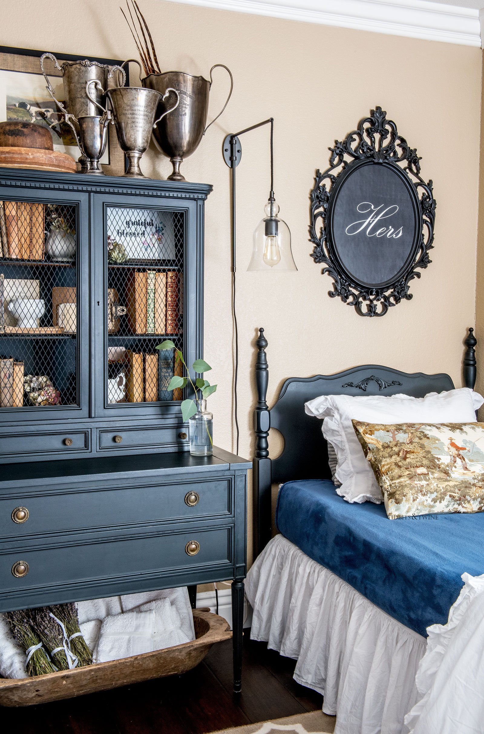 Guest bedroom with twin beds and cabinet painted black with pops of blue