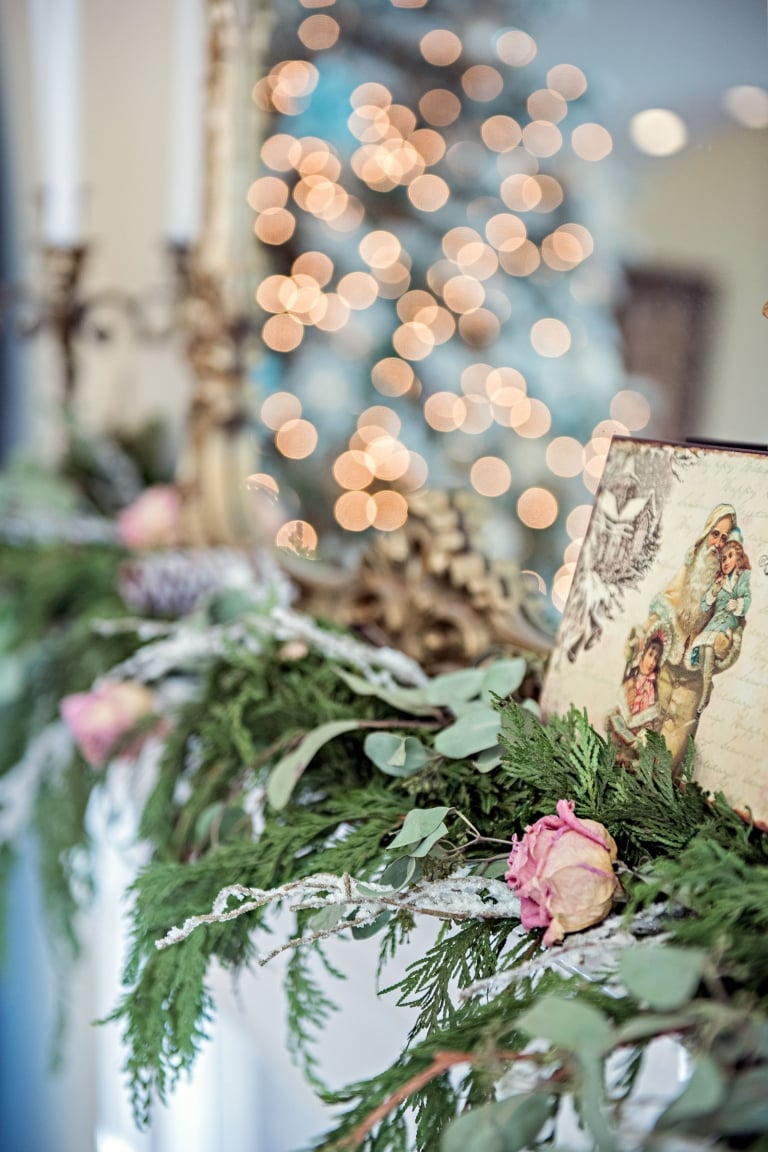 christmas cedar garland on mantel with dried pink roses and snowy branches added