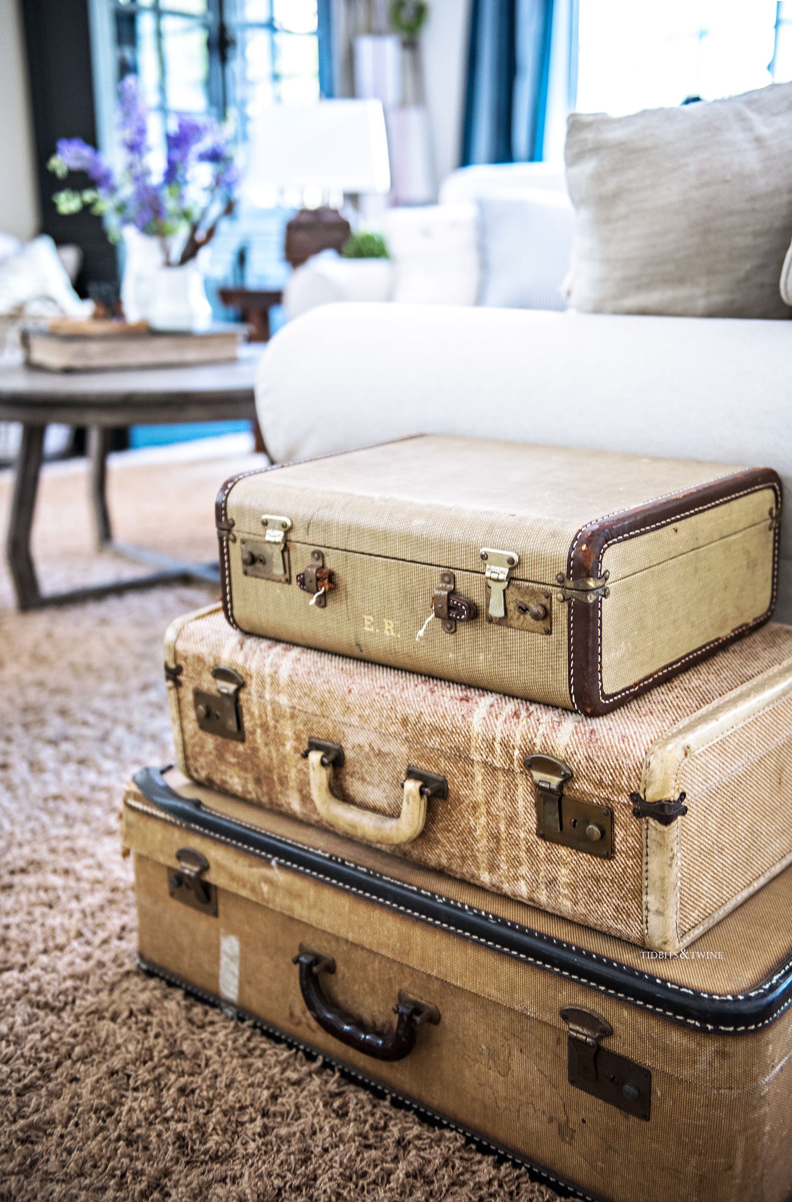 Stacked vintage suitcases used as a side table in a family room