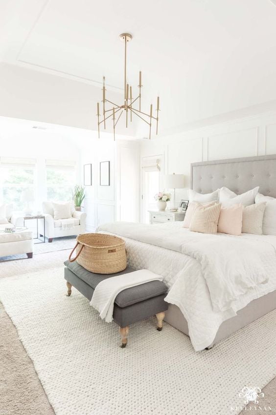 Master bedroom with gray tufted headboard and seating area