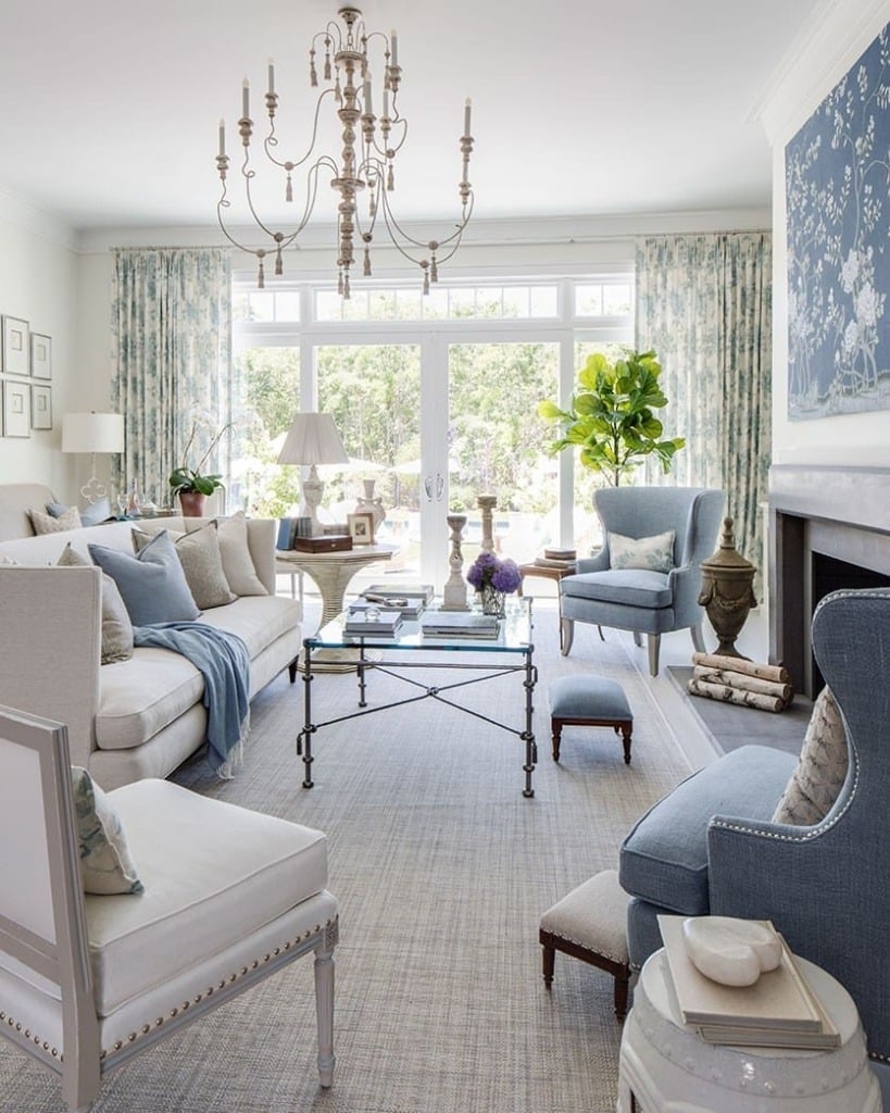 Traditional living room with white sofa and blue chairs around fireplace