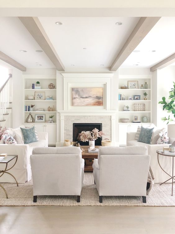 White family room with two chairs and two slipcovered sofas.