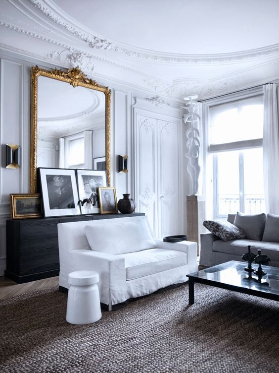 white french living room with large gold mirror and artwork leaning in front