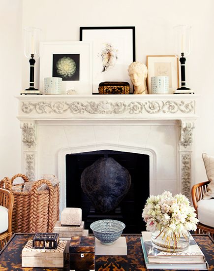 white fireplace with several framed images leaning on the mantel in a living room