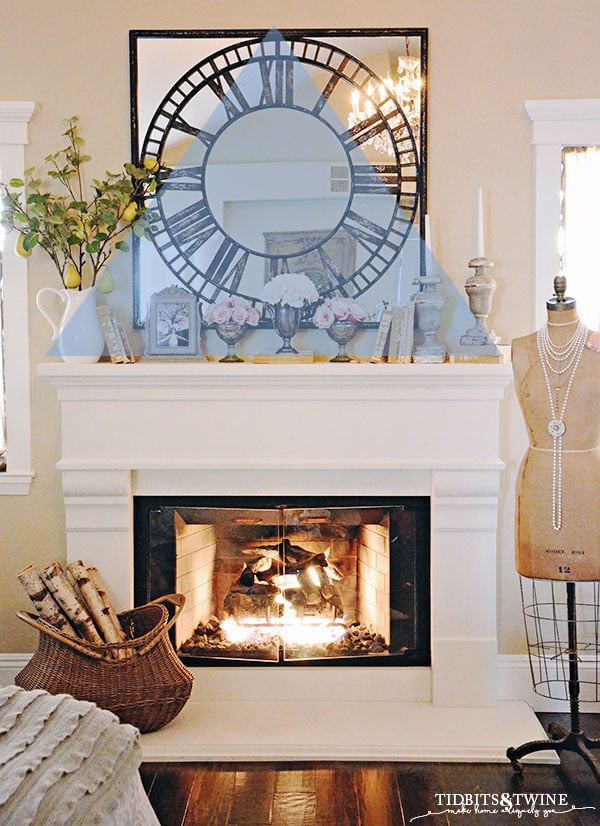 Create a triangle of decor above white french fireplace mantel next to antique dress form