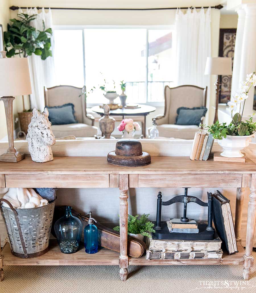 Sofa table with vintage books and greenery in a French inspired living room