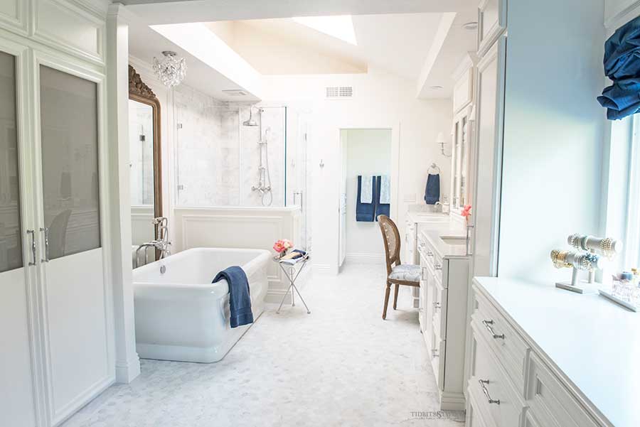 White marble master bathroom with freestanding tub and hexagon floor