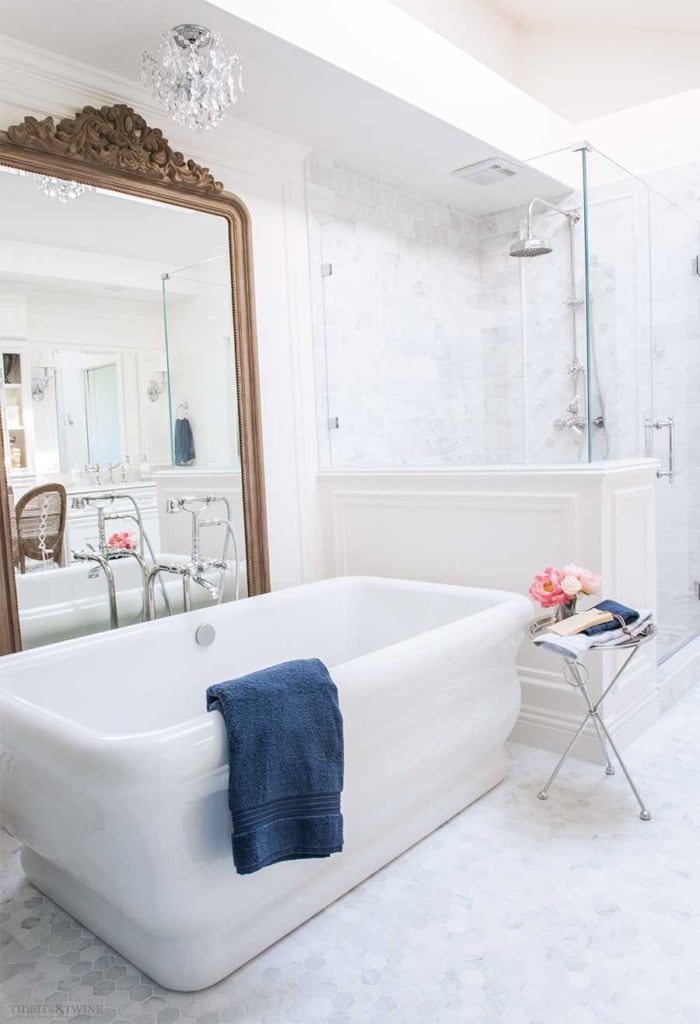 Elegant french master bathroom with freestanding tub and ornate DIY wood floor mirror