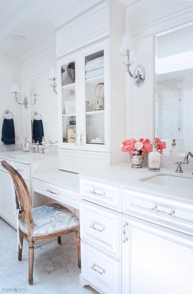 White french master bathroom vanity with makeup area and sconces and carrara marble