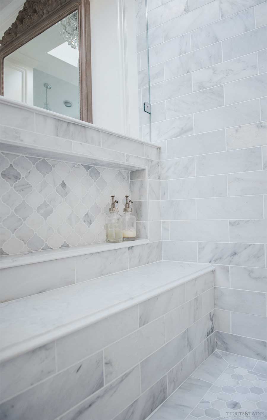 Oversized shower niche in carrara marble subway tile with quartz bench seat