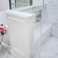 Shower pony wall with carrara marble bench and niche