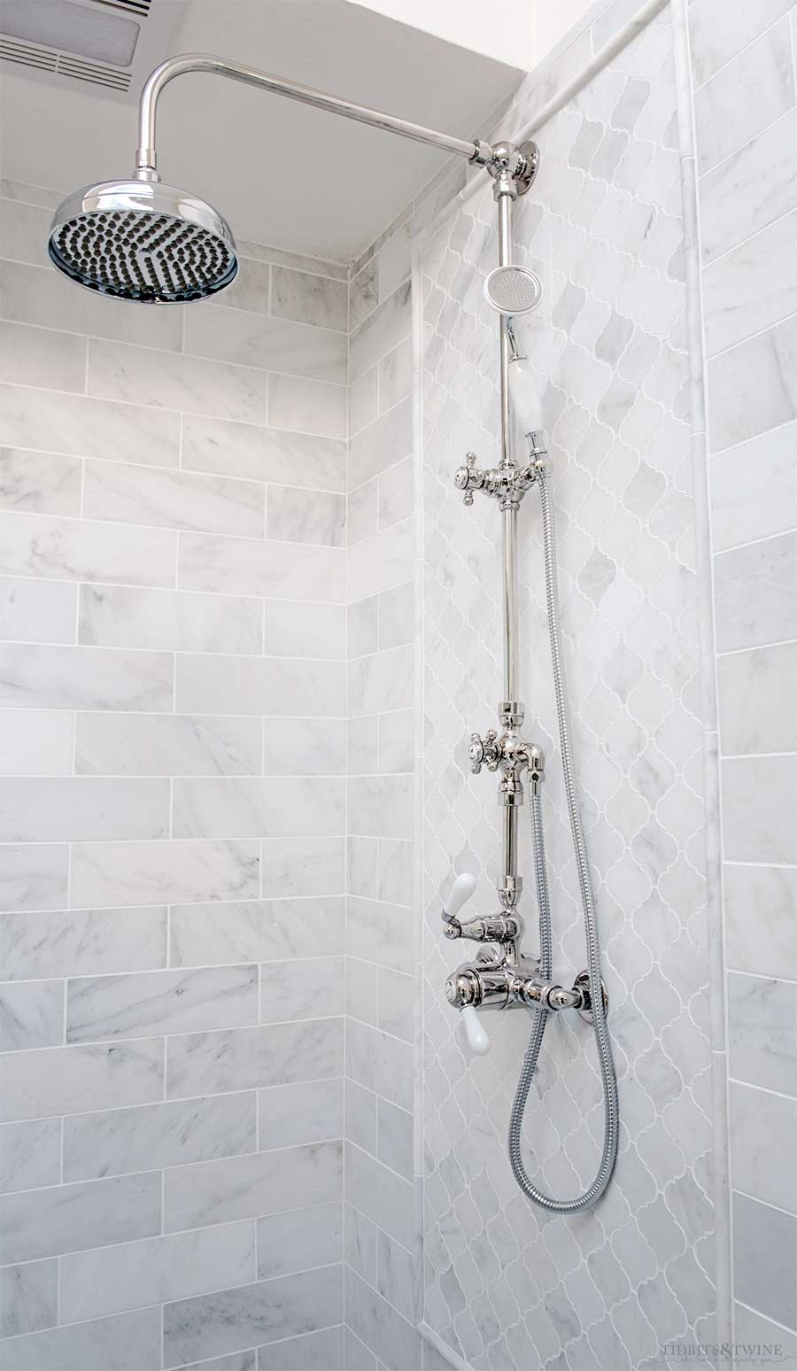 Sigma exposed pipe shower with marble subway tile in French elegant bathroom